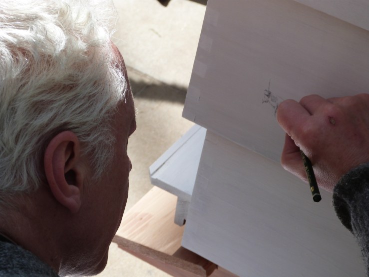 Paul Evans makes a drawing of a plasterer's bee directly onto the hive.